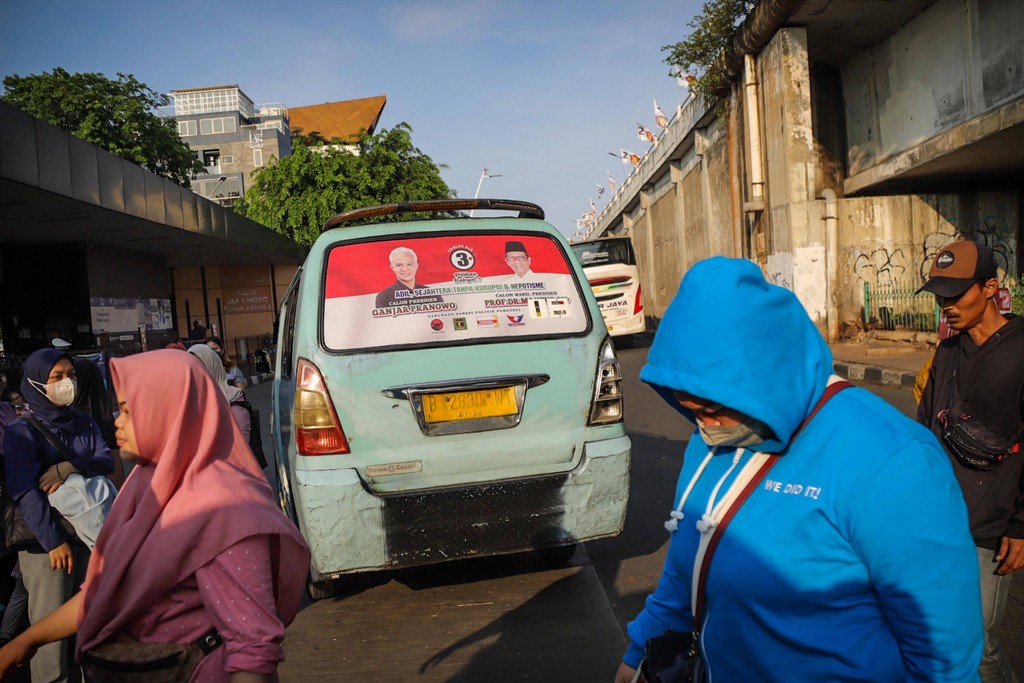 Alat peraga kampanye (APK) terpasang pada kaca belakang angkot di kawasan Tanah Abang, Jakarta, Jumat (5/1). Foto: Jamal Ramadhan/kumparan