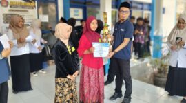 Kepala Bidang SD Dinas Pendidikan Kabupaten Sampang, Yusuf, menyerahkan piala dan piagam kepada salah satu pemenang lomba Festival Tunas Bahasa Ibu 2026 di pelataran gedung SMPN 4 Sampang, pada Rabu (30/9/2026) FOTO: Acung/RADAR EXPOSE.